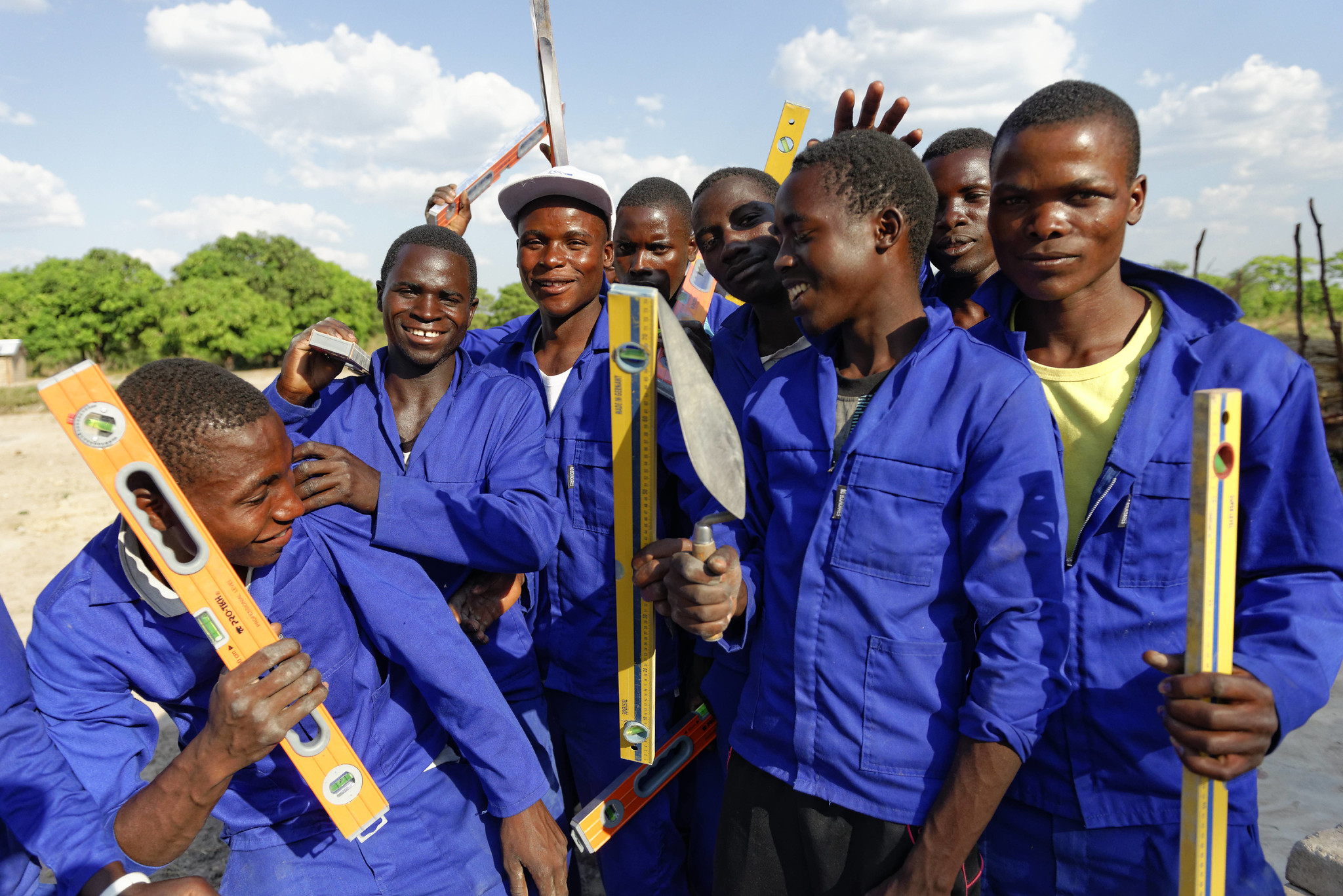 Construction workers holding tools and levels in Zambia