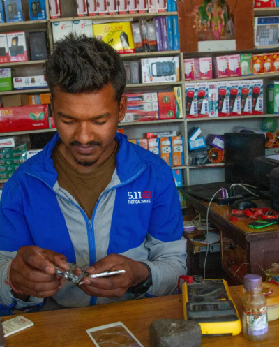A mobile repairman in Nepal A man repairing a mobile